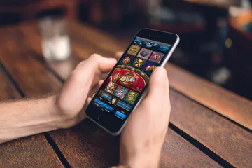 A cheerful woman in traditional clothing using her smartphone during a festive moment, showing how easily the JLPLUS app fits into everyday life.