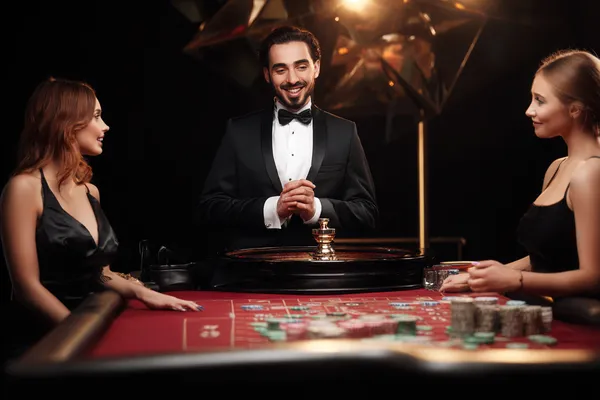 A woman in a luxurious green gown next to an ornate roulette wheel, capturing the upscale casino mood of JLPLUS.